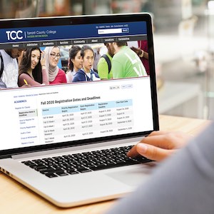 An image of a laptop on a desk showing the TCC web page with registration info on it