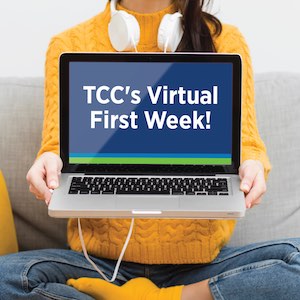 A woman holding a laptop with an image on the screen that says, "TCC Virtual First Week"