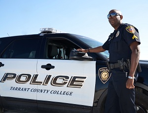 TCC Police Officer posing with a TCC Police car